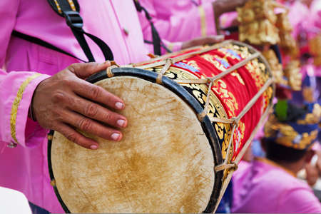Balinese man play music on traditional drum Kendang -  musicians of Baleganjur (Gamelan) orchestra. Arts festivals in Indonesia, culture of Bali and Indonesian people. Asian travel background.の写真素材
