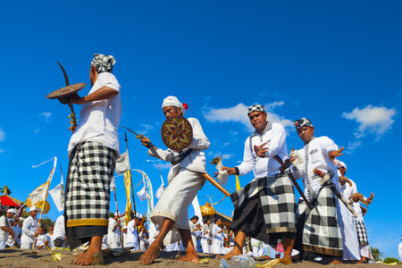 Bali Island, Indonesia - March 18, 2015: Traditional men trance dance with ritual fighting and offerings for balinese gods and spirits. Temple cleanse ceremony Melasti before silence day Nyepi.のeditorial素材