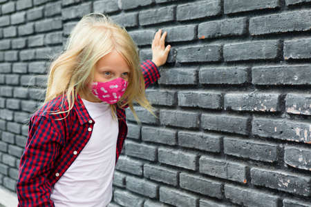 Young child feeling bad go outside. Girl wear stylish protective face mask due coronavirus COVID 19 world pandemic.の写真素材