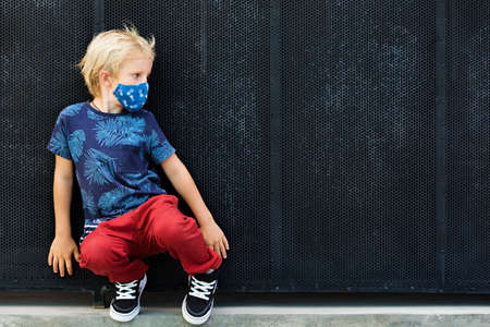 Portrait of child in funny protective mask. New rules to keep social distancing, wear face covering...
