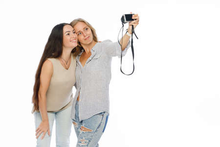 Positive friends portrait of two happy young women making selfie, sure funny faces, joy, emotions,...