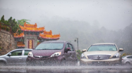 Cars under torrential rain. Heavy tropical rain on city street. Rainy season in Asia, weather forecasts of natural disasters.の写真素材