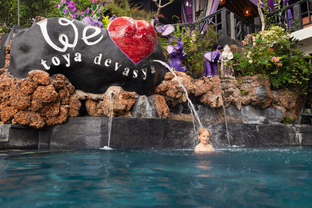 Bali, Indonesia - January 21, 2020: Natural hot spring Toya Devasya beside Batur volcano. Infinity pool with hot water and beautiful lake view. Popular travel destination on family summer holidayのeditorial素材