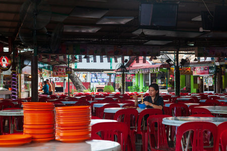 Georgetown, Penang, Malaysia - September 02, 2014: Young woman eating noodle at food market in historical Georgetown, Penang, Malaysiaのeditorial素材