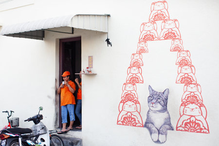 Georgetown, Penang, Malaysia - September 03, 2014: Women resting at the shop entrance at one of the main streets in historical Georgetown, Penang, Malaysiaのeditorial素材