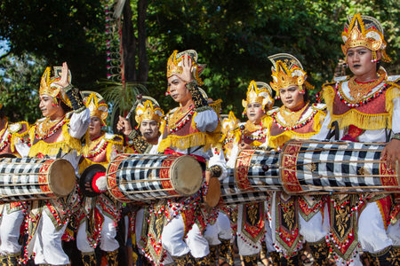 Denpasar, Bali island, Indonesia - June 11, 2016: Young musicians dressed in ethnic Balinese people costumes play traditional orchestra music at ritual temple procession at street of Denpasarのeditorial素材