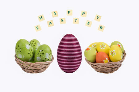 Easter eggs in a basket with a happy wishes on white background .
