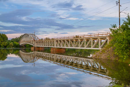 River which is almost to point to become flood and with a bridge reflecting on water and with a nice sky scenery.の写真素材