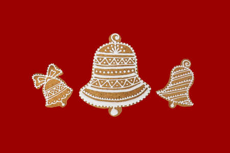 Homemade three bells gingerbread and honey cookies on nice christmas theme on red background.の写真素材