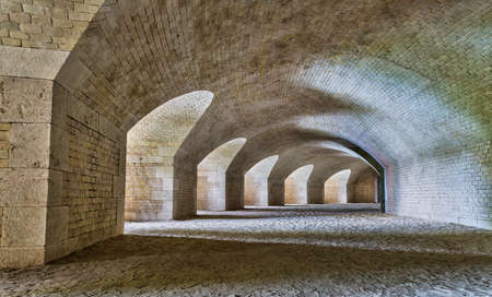 Castle tunnel interior with a series of arches in a ruined bastion fortress.の写真素材
