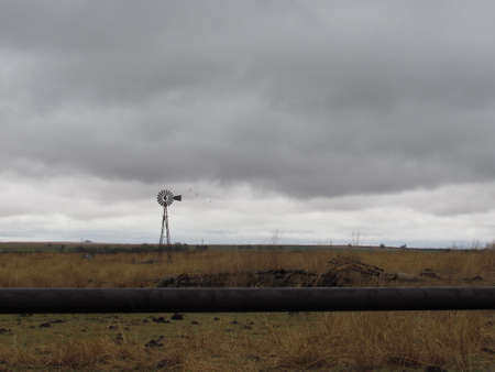 Old metal windmill on a rainy afternoonの写真素材