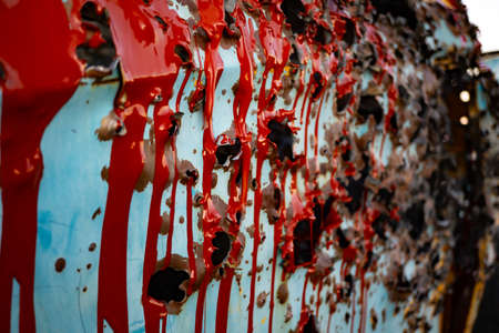 Bullet holes in an old truck covered with paintの写真素材