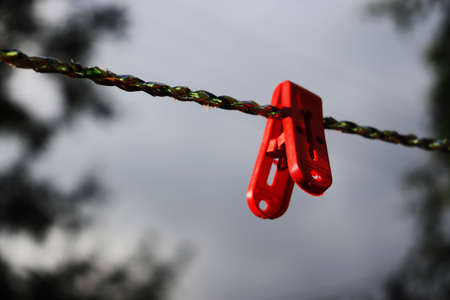 isolated plastic red color clothes clip on a rope