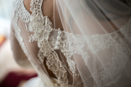 Bride putting on her white wedding dressの写真素材