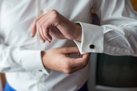 The man in the white shirt in the window dress cufflinks.の写真素材