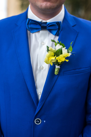 Wedding beautiful boutonniere on suit of groom. Man in blue suit and shirt.の写真素材