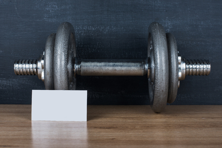 dumbbell on a black background and white card of your text or logoの写真素材