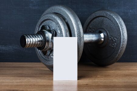 dumbbell on a black background and white card of your text or logoの写真素材