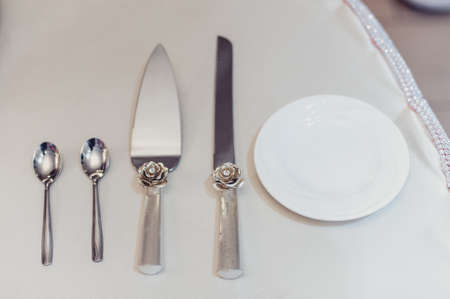 Wedding. Banquet. The chairs and table for guests, decorated with candles, served with cutlery and crockery and covered with a tablecloth. The table stands on a green lawn in the backyard banquet areaの写真素材