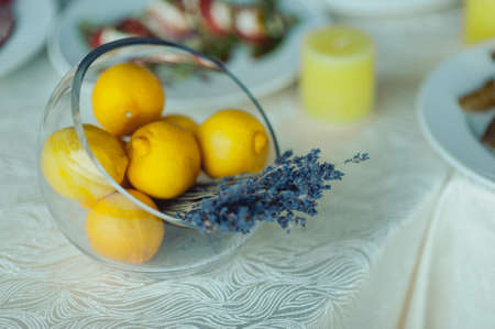 Wedding. Banquet. The chairs and table for guests, decorated with candles, served with cutlery and crockery and covered with a tablecloth. The table stands on a green lawn in the backyard banquet areaの写真素材