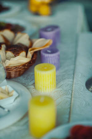 Wedding. Banquet. The chairs and table for guests, decorated with candles, served with cutlery and crockery and covered with a tablecloth. The table stands on a green lawn in the backyard banquet areaの写真素材