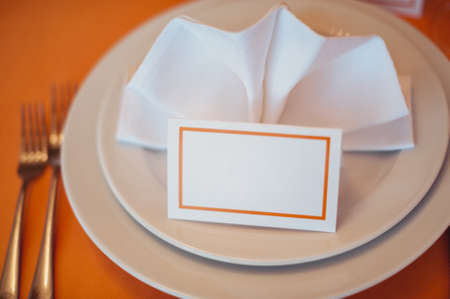 Wedding. Banquet. The chairs and table for guests, decorated with candles, served with cutlery and crockery and covered with a tablecloth. The table stands on a green lawn in the backyard banquet areaの写真素材