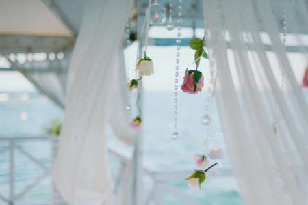 Original wedding floral decoration in the form of mini-vases and bouquets of flowers hanging from the ceilingの写真素材