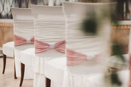 Decoration of chairs at the wedding. Beautiful chairs with decorationsの写真素材