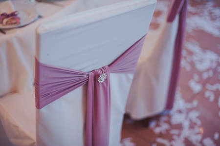 Decoration of chairs at the wedding. Beautiful chairs with decorationsの写真素材