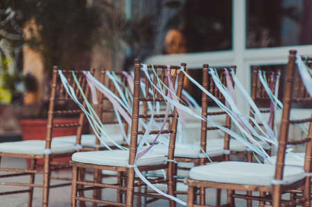 Decoration of chairs at the wedding. Beautiful chairs with decorationsの写真素材