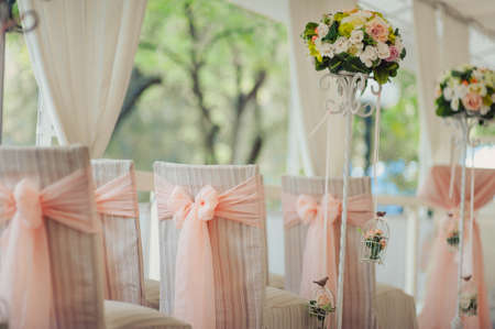 Decoration of chairs at the wedding. Beautiful chairs with decorationsの写真素材