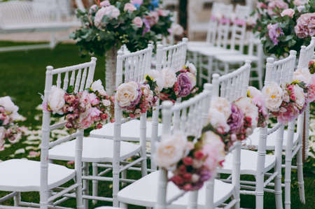 Decoration of chairs at the wedding. Beautiful chairs with decorationsの写真素材