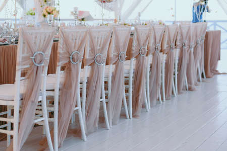 Decoration of chairs at the wedding. Beautiful chairs with decorationsの写真素材