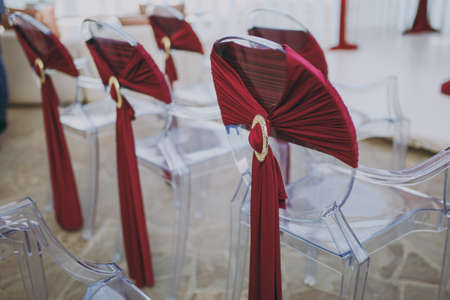Decoration of chairs at the wedding. Beautiful chairs with decorationsの写真素材