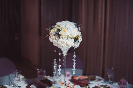 Original wedding floral decoration in the form of mini-vases and bouquets of flowers hanging from...