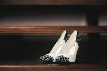Bride wedding shoes with high heels and silver brilliant earrings on sheep's clothingの写真素材