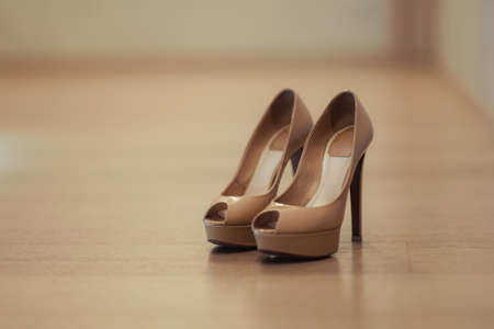 Bride wedding shoes with high heels and silver brilliant earrings on sheep's clothing