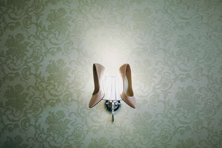 Bride wedding shoes with high heels and silver brilliant earrings on sheep's clothingの写真素材