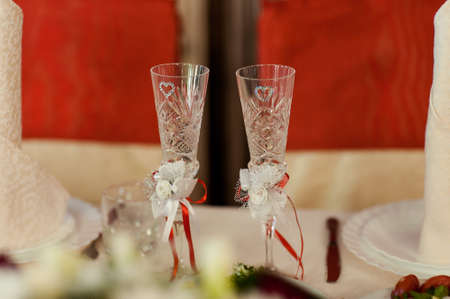 Two glasses of champagne on the background of the wedding bouquet of pink roses. Soft focus,...