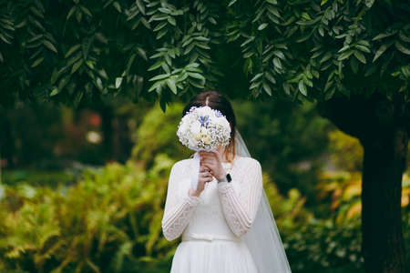 Bride holding big wedding bouquet on wedding ceremonyの写真素材