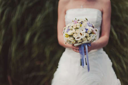 Bride holding big wedding bouquet on wedding ceremony