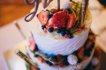 Beautiful white and colored wedding cake. A bride and a groom is cutting their wedding cakeの写真素材