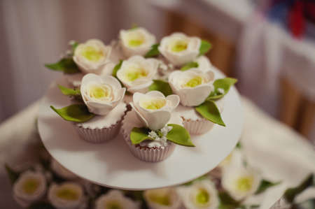 Beautiful white and colored wedding cake. A bride and a groom is cutting their wedding cake