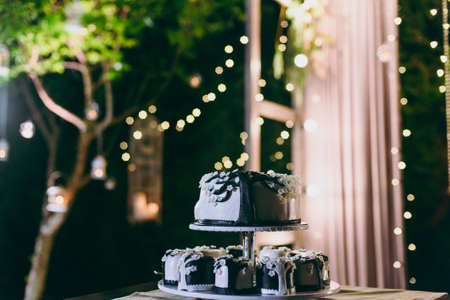 Beautiful white and colored wedding cake. A bride and a groom is cutting their wedding cakeの写真素材