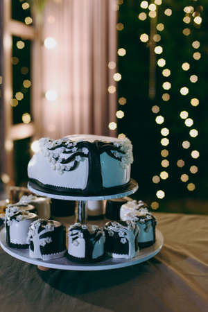 Beautiful white and colored wedding cake. A bride and a groom is cutting their wedding cakeの写真素材