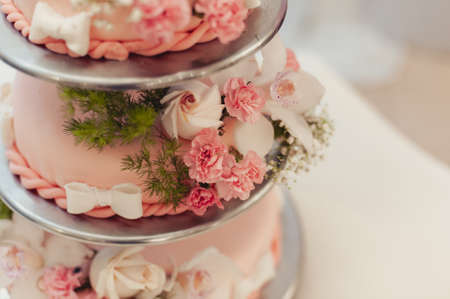 Beautiful white and colored wedding cake. A bride and a groom is cutting their wedding cakeの写真素材