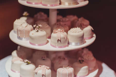 Beautiful white and colored wedding cake. A bride and a groom is cutting their wedding cakeの写真素材