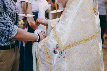Hands of bride and groom tied Wedding towels. The priest binds the bride's hand towel. hands of young couples in the church. couple holding hands in towel at church ceremony. Wedding day.の写真素材