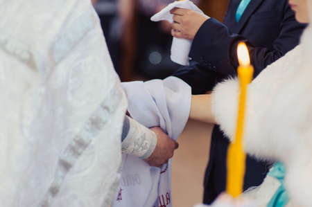 Hands of bride and groom tied Wedding towels. The priest binds the bride's hand towel. hands of young couples in the church. couple holding hands in towel at church ceremony. Wedding day.の写真素材