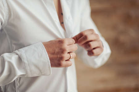 man buttoning his shirtの写真素材